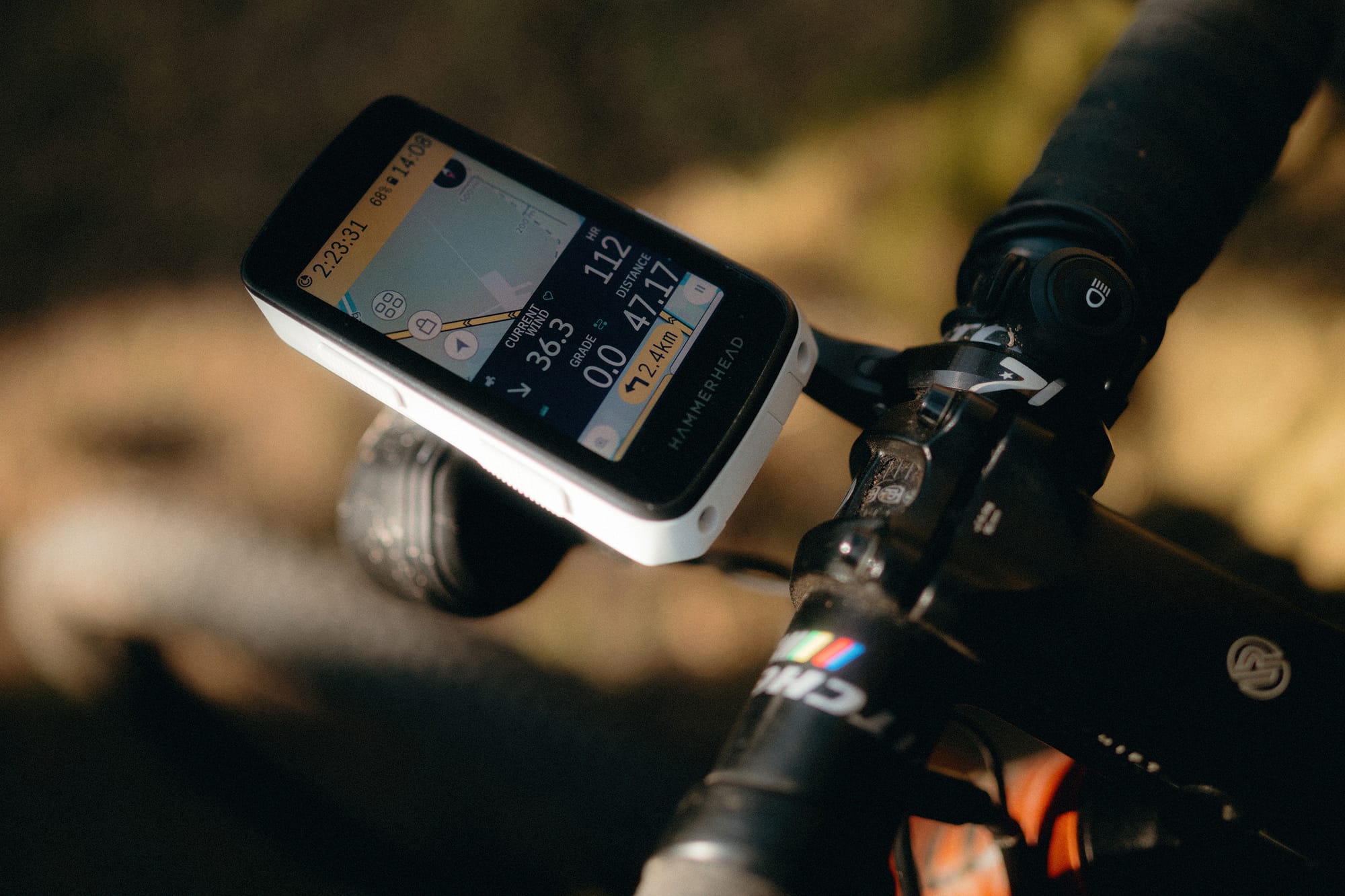 Close-up of a Hammerhead Karoo bike computer showing 36.3 km/h wind, 47.17 km distance, and a speed of 12.4 km/h. Mounted on a drop-bar gravel bike.